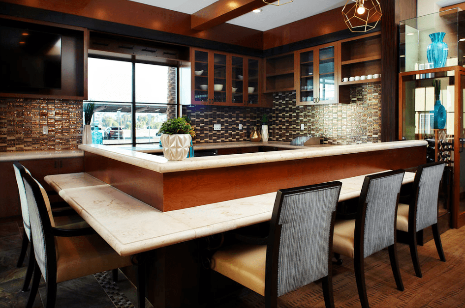A modern kitchen with stylish cabinetry, a tiled backsplash, and bar seating.