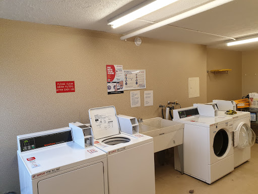 A clean and organized laundry room with washing machines and a drying area.