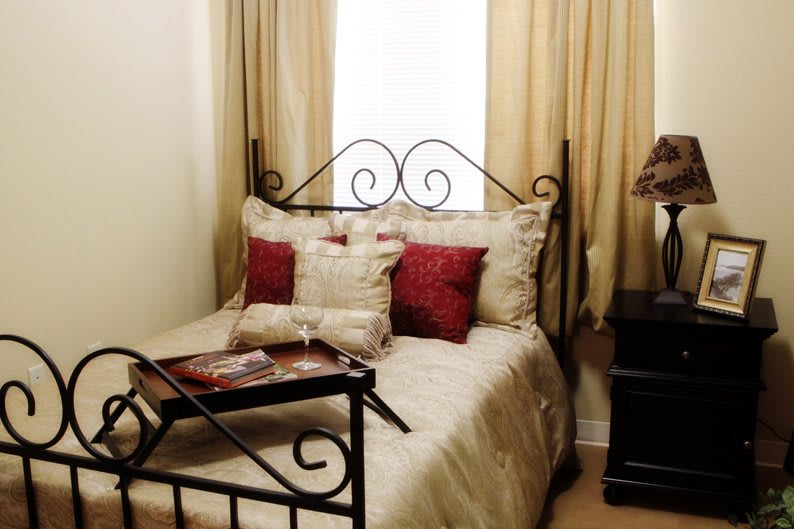 Cozy bedroom with a decorative bed and pillows, featuring a breakfast tray.