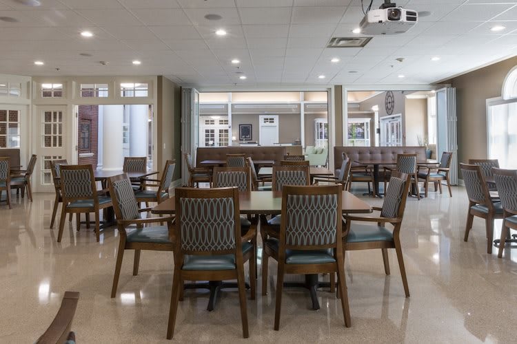 A modern indoor dining area with neatly arranged tables and chairs.
