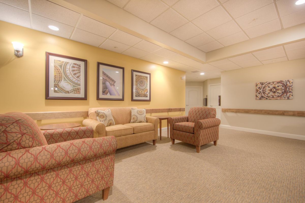 A cozy lobby area with comfortable seating and framed artwork on the walls.