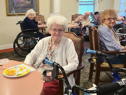 Elderly residents enjoying their meal in a care facility.