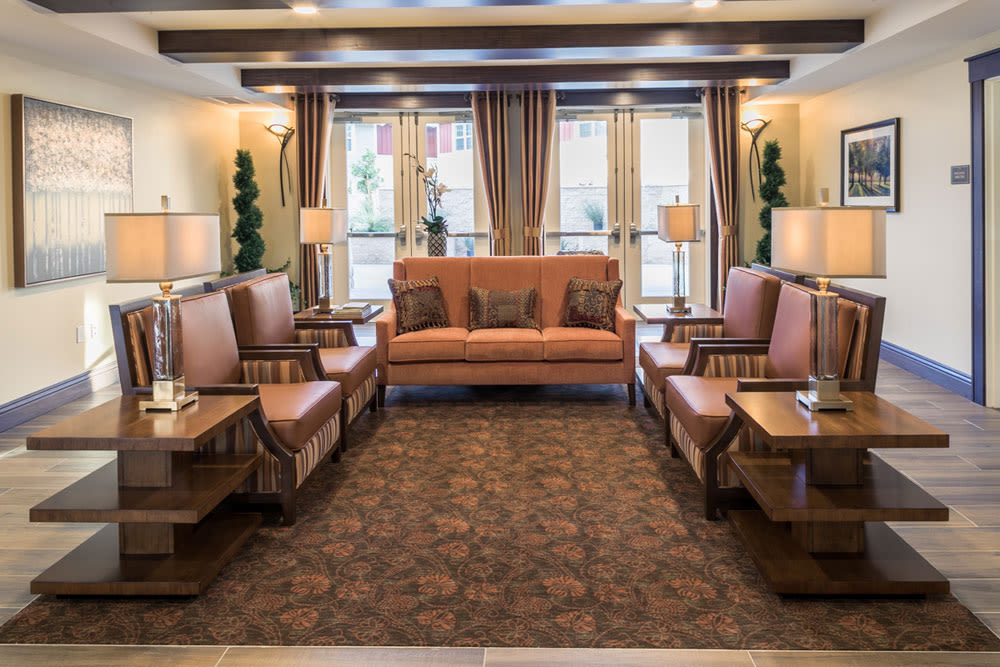 A stylish living room with a sofa, multiple chairs, and decorative lighting.