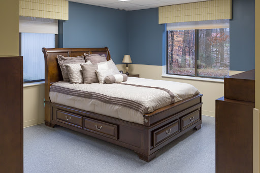 A beautifully designed wooden bed with elegant linens in a cozy bedroom setting.