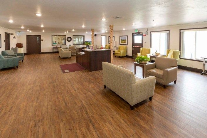 A spacious and modern lobby with comfortable seating and wooden flooring.