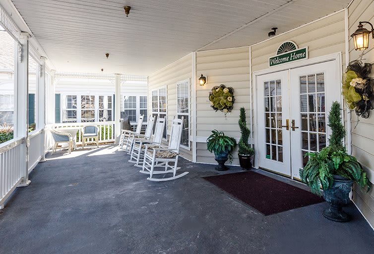 A welcoming porch with rocking chairs and potted plants by the entrance.