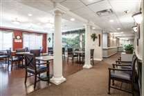 A spacious dining area with neatly arranged tables and chairs, featuring decorative columns.