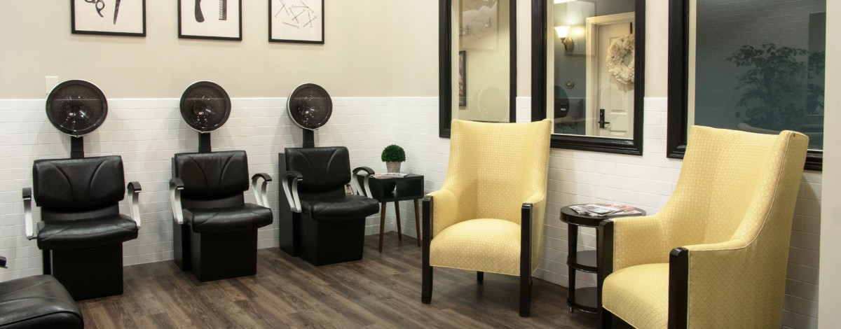 A modern hair salon waiting area with stylish chairs and decor.