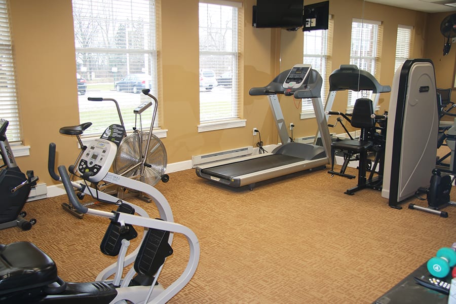 A small gym room with exercise equipment including treadmills and stationary bikes.