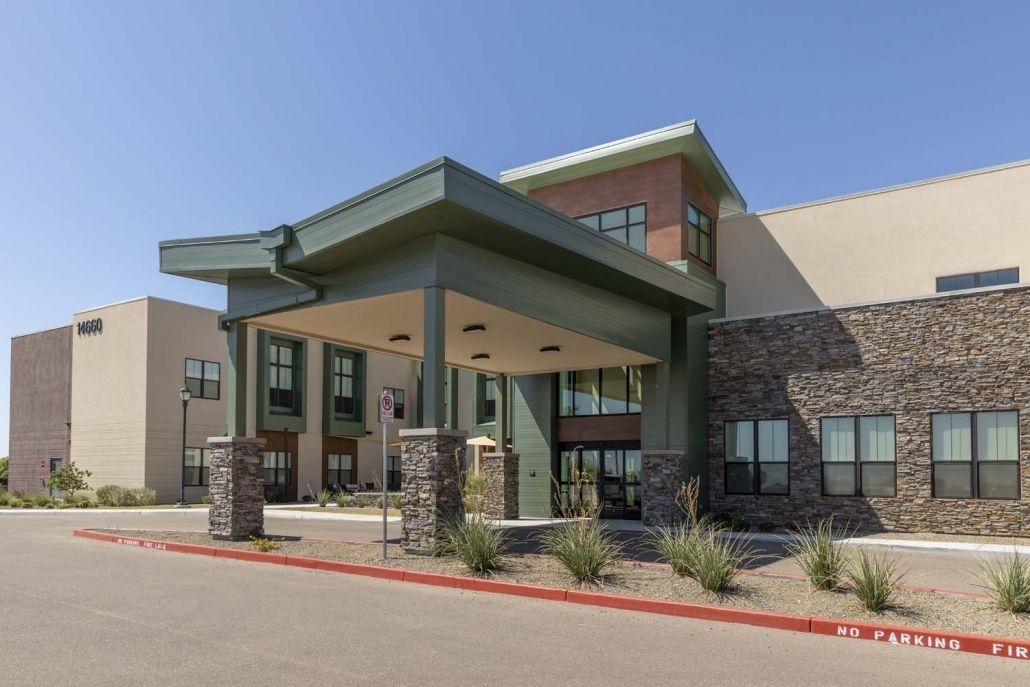 A modern commercial building with a prominent entrance and well-maintained landscaping.