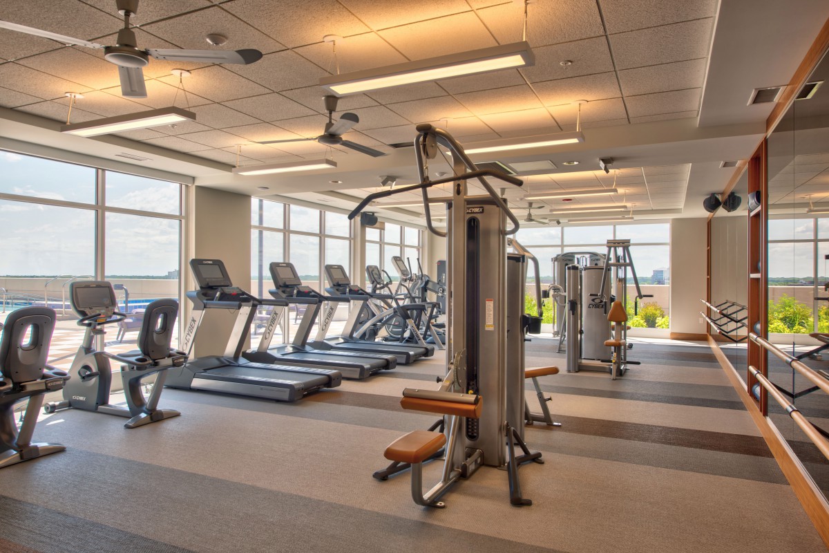 A modern gym with various exercise equipment including treadmills and weight machines.
