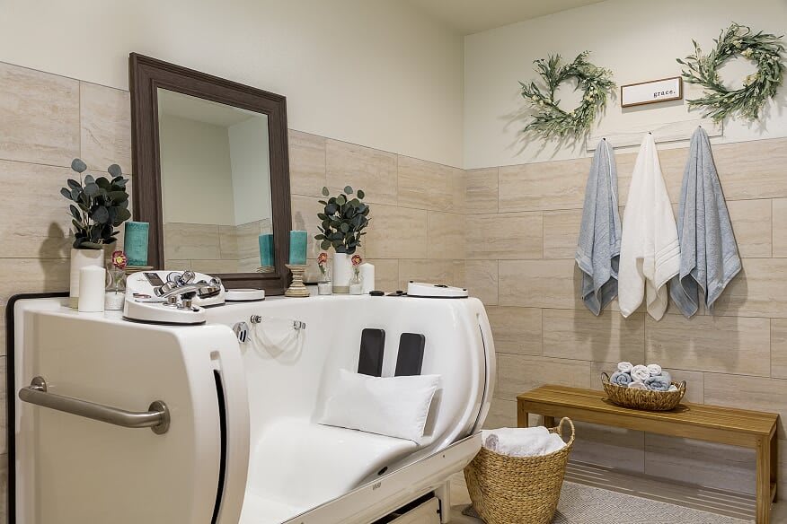 A cozy bathroom featuring a modern bathtub, decorative accents, and neatly arranged towels.