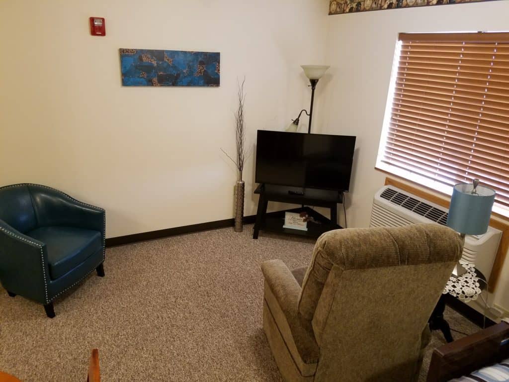 A cozy living room with a chair, TV, and decorative elements.