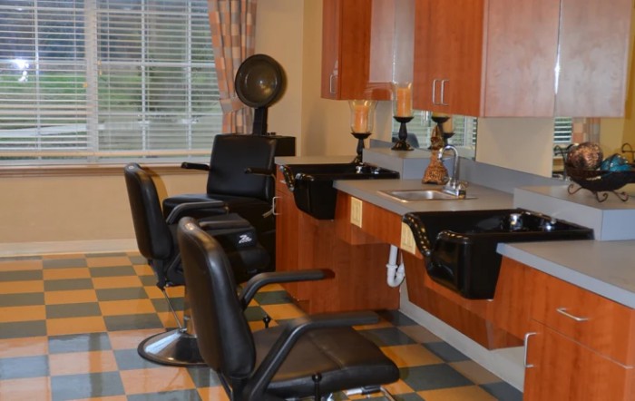 An empty hair salon with barber chairs and washing stations ready for clients.