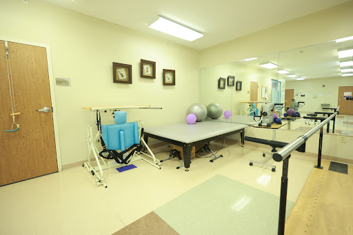 A well-equipped physical therapy room featuring various exercise tools and a therapy table.