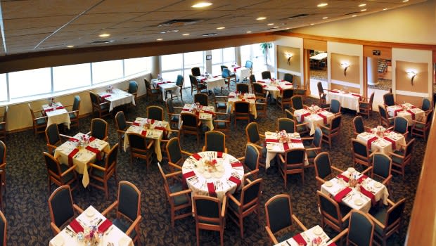 An empty restaurant dining area with tables set for service.
