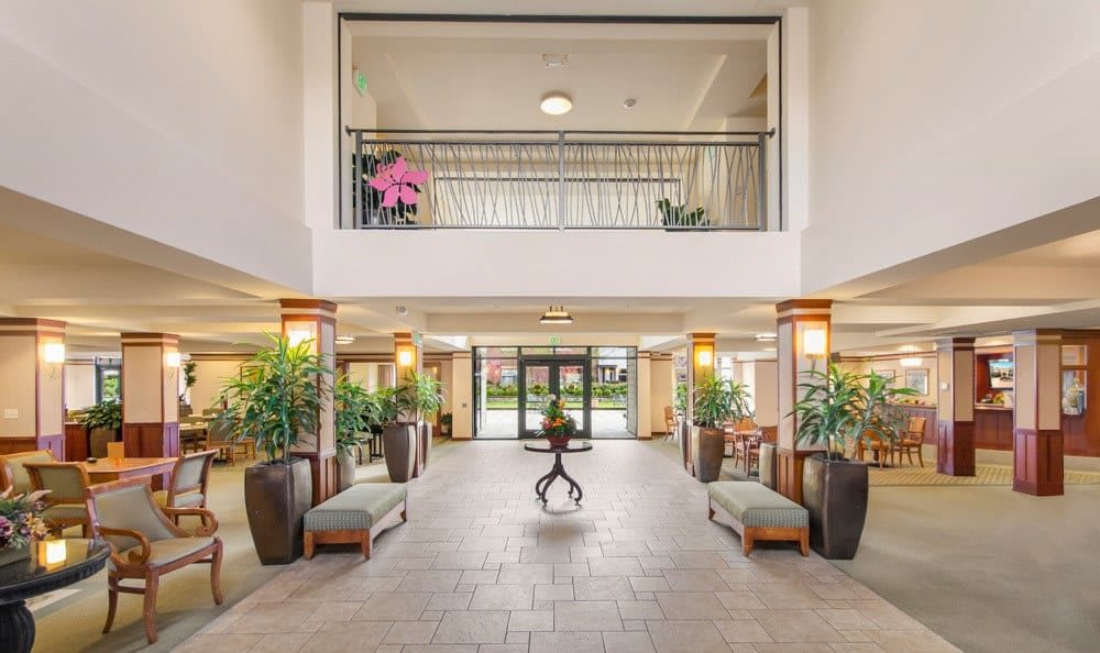 A spacious and modern hotel lobby with elegant decor and greenery.