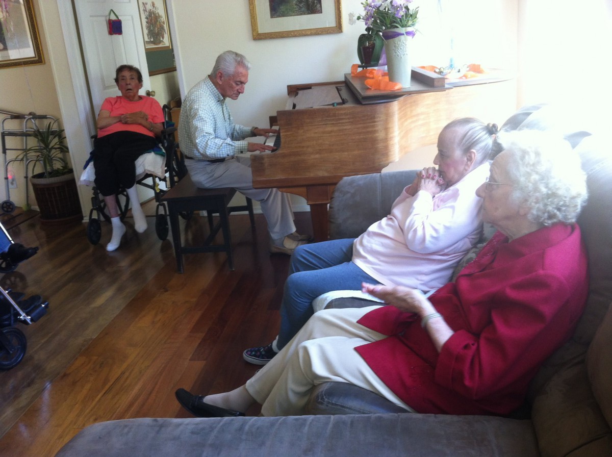 Elderly individuals enjoying music in a living room setting.