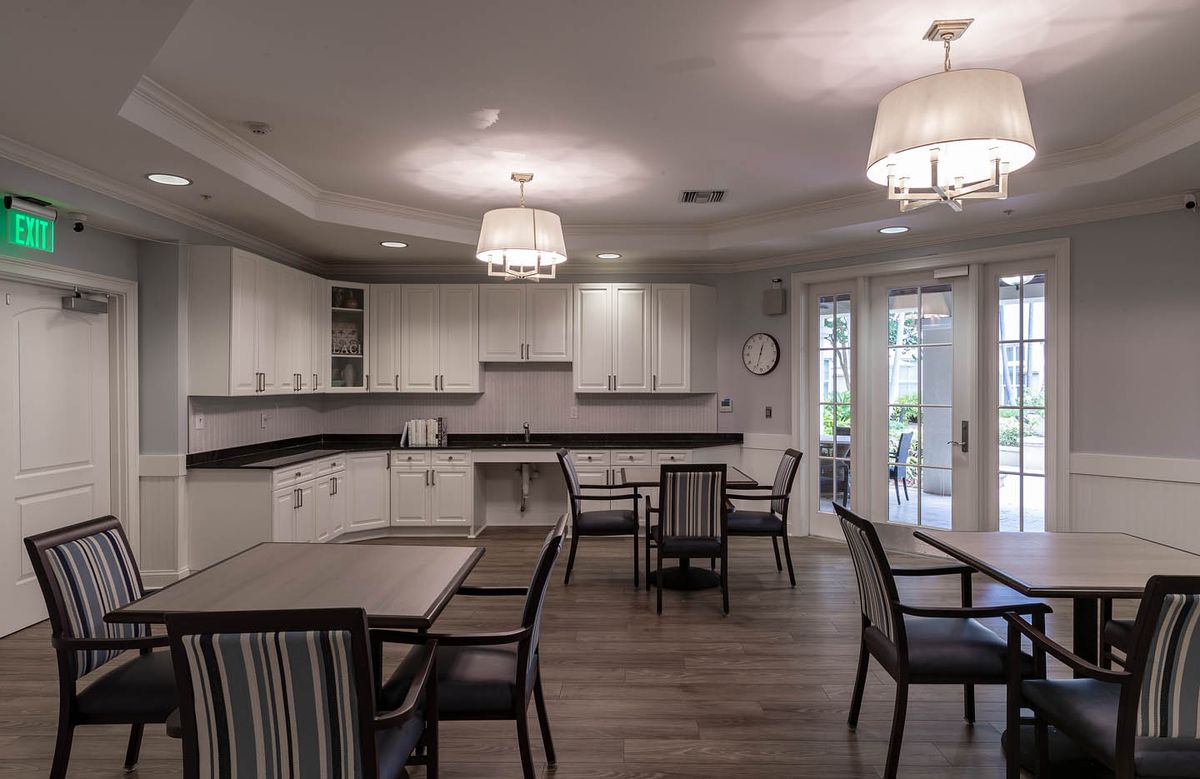 A modern kitchen and dining area featuring sleek cabinets, contemporary lighting, and stylish furniture.