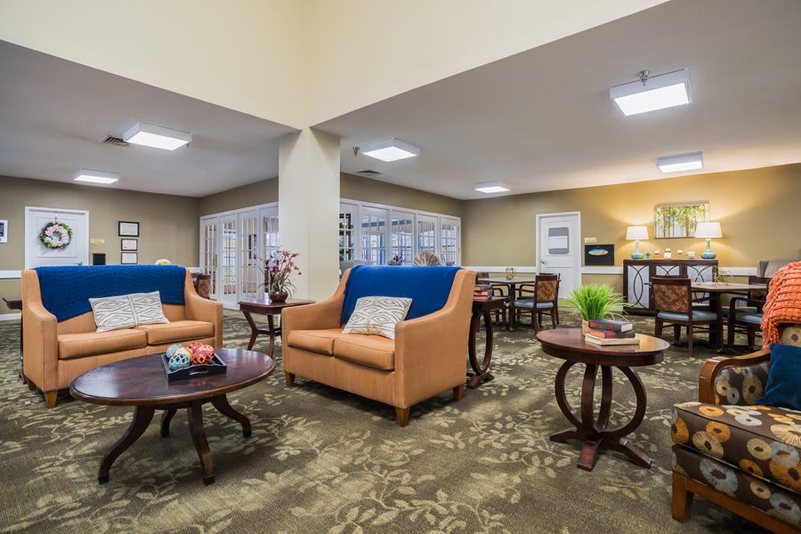 A cozy living room with sofas, coffee tables, and warm decor.