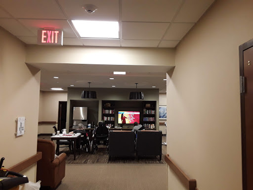A view of a common area with seating and a television, leading to an exit.