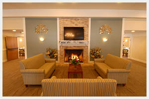 A cozy living room with a fireplace, sofas, and a mounted television.