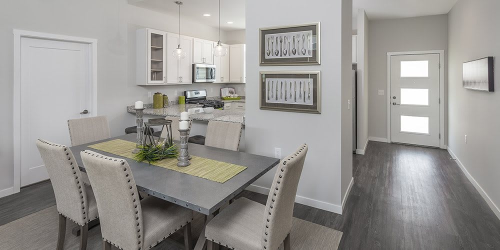 Modern dining area with a view into the kitchen, featuring elegant furnishings and contemporary decor.
