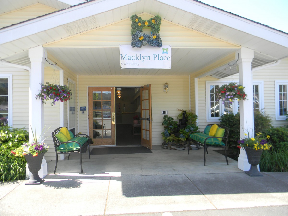 A welcoming entrance to a building with decorative plants and seating area.