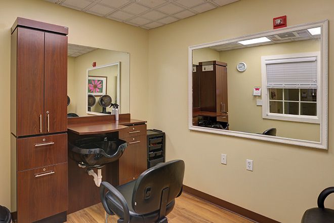 A cozy hair salon interior featuring a styling station with mirrors and chairs.