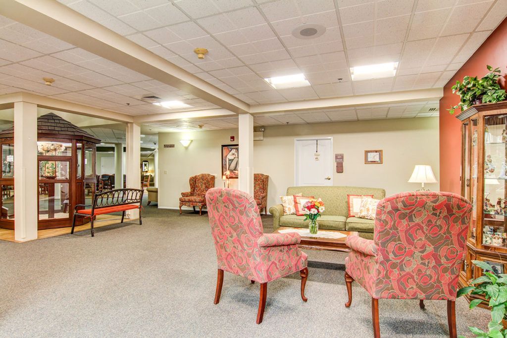 A cozy seating area with armchairs and a sofa in a warmly lit room.