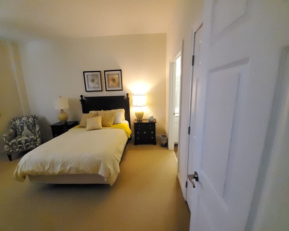 A cozy, minimalist bedroom with a neatly made bed and soft lighting.