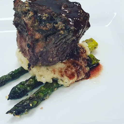 A beautifully presented grilled steak served on a bed of asparagus, showcasing culinary artistry.