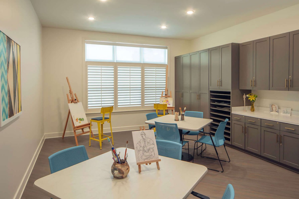An inviting art studio with tables, easels, and comfortable seating.