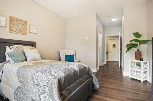 A cozy and modern bedroom featuring a neatly made bed, stylish decor, and warm wooden flooring.