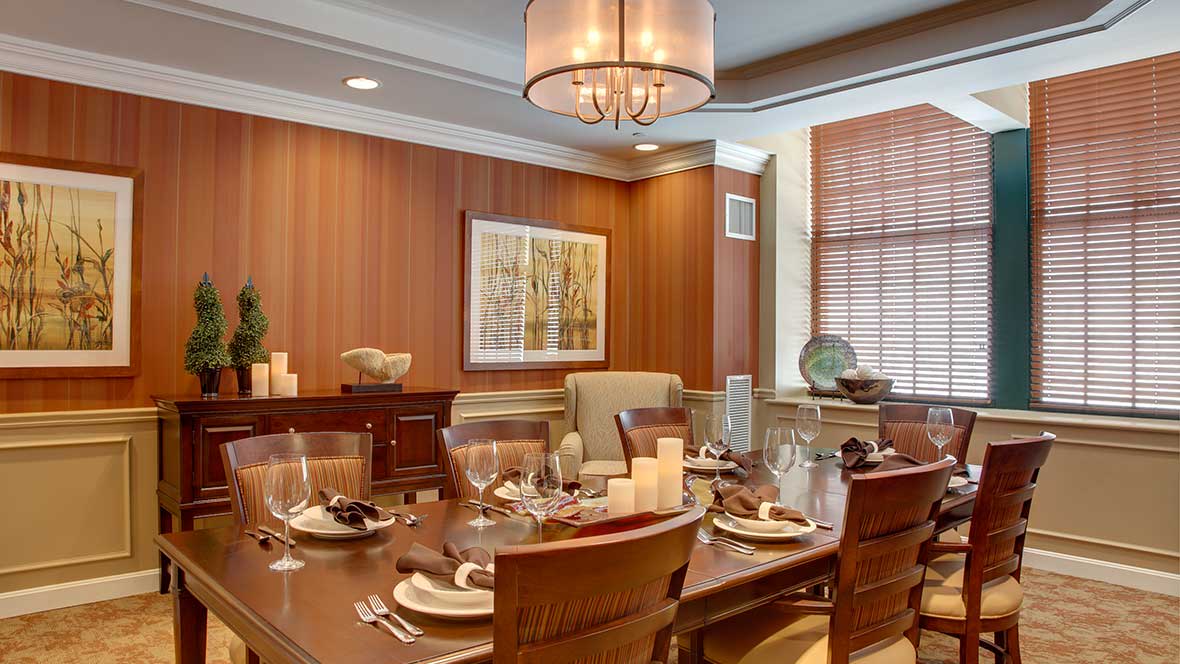 A beautifully set dining room with a modern chandelier and elegant decor.