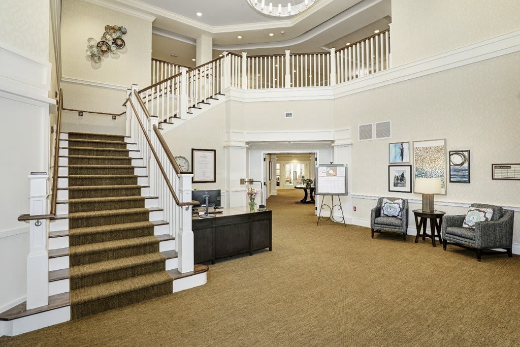 A spacious and well-decorated lobby with a staircase leading to the upper level.