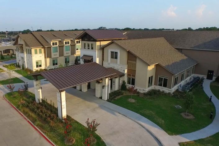 Aerial view of a suburban residential building with landscaped surroundings.