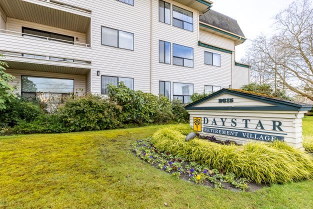 A residential apartment building with a landscaped entrance and a sign displaying the name 'Daystar'.