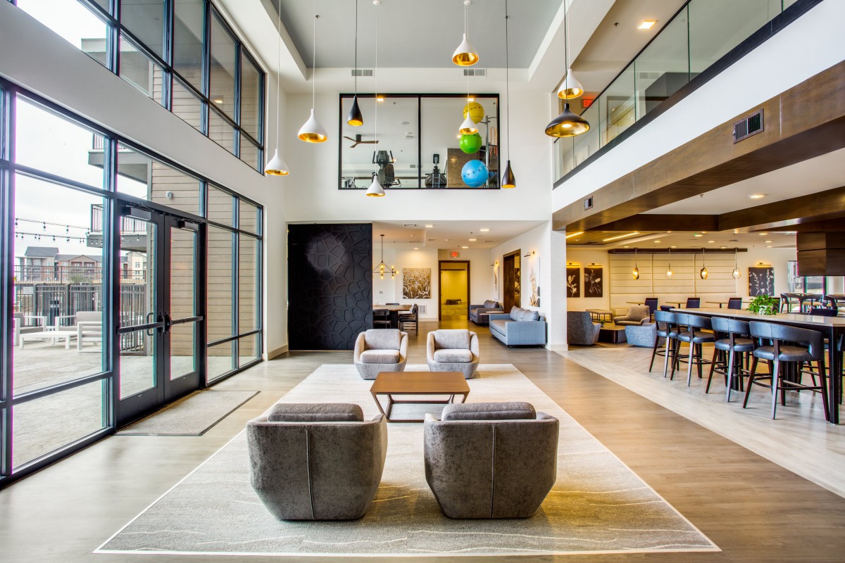 A modern lobby featuring a spacious seating area with stylish furniture and contemporary lighting.