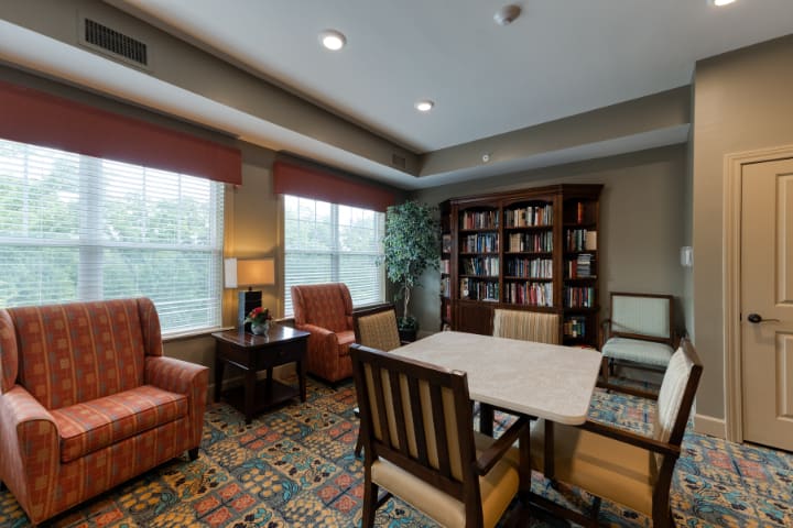 A cozy reading room with comfortable seating and a bookshelf filled with books.