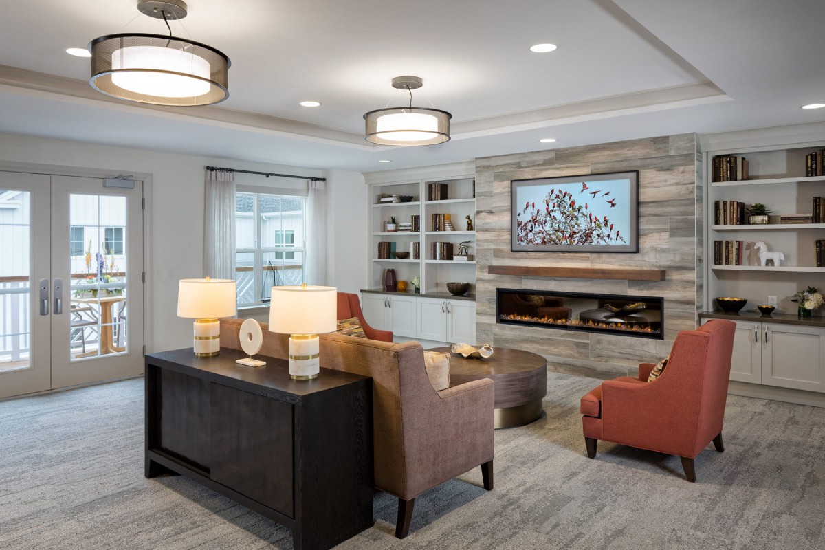 A modern living room featuring comfortable seating, stylish lighting, and a cozy fireplace.