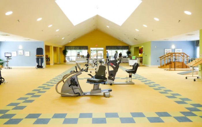 A spacious and well-lit gym with modern exercise equipment.