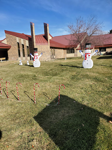 A festive display featuring snowmen and candy canes set against a sunny backdrop.