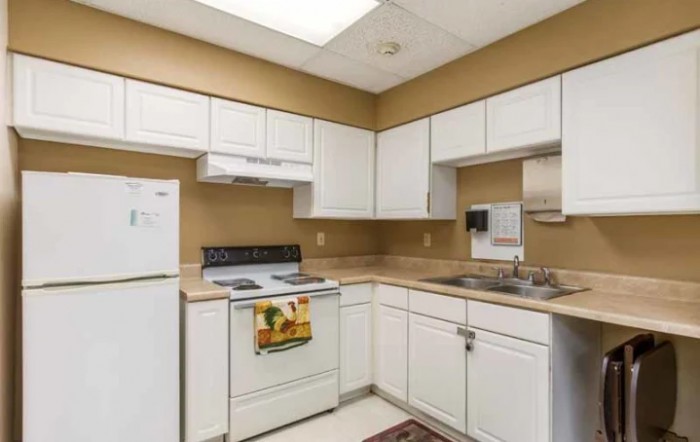 A clean and modern kitchen with white cabinetry and standard appliances.