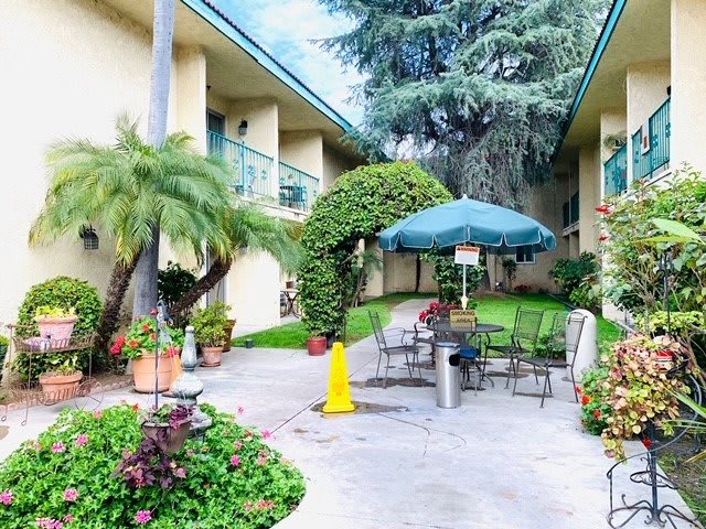 A tranquil courtyard with outdoor seating and lush greenery.