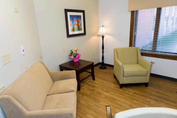 A cozy living room with a sofa, armchair, and decorative elements.