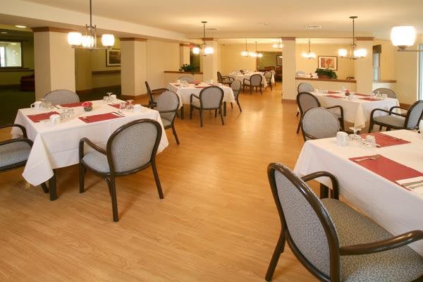 An empty restaurant dining area with neatly arranged tables and chairs.