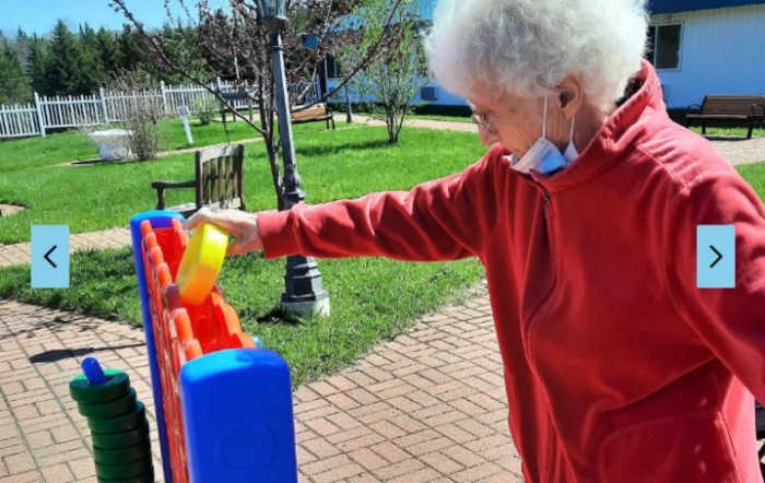 An elderly person enjoying an outdoor game on a sunny day.