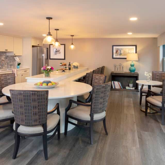 A modern open-concept kitchen and dining area with stylish lighting and wood flooring.