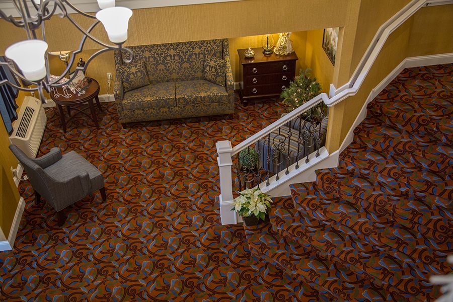 A cozy lobby area with a patterned carpet and classic furniture.
